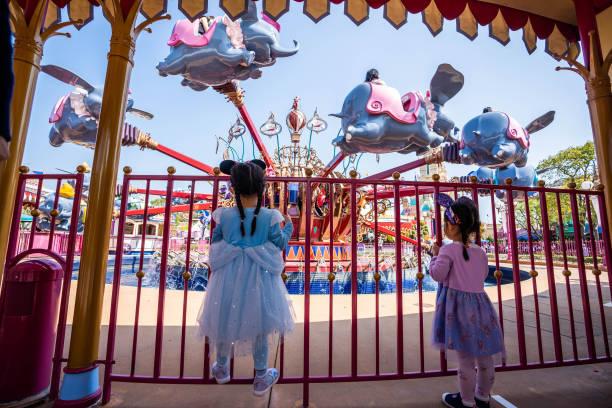HONG KONG, CHINA - 2021/02/19: Two young girls line up for the ride of Dumbo the Flying Elephant while maintaining social distance during the reopening of the Hong Kong Disneyland Resort.
The Hong Kong Disneyland Resort reopens its door to visors as the city's government has relaxed the lockdown restrictions as the infection rate of the Covid-19 coronavirus has reduced significantly in recent days. (Photo by Geovien So/SOPA Images/LightRocket via Getty Images)