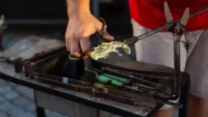 אומן מעצב פסלון זכוכית חם בעבודת נפח